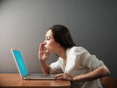 woman whispering secrets to her laptop clipart
