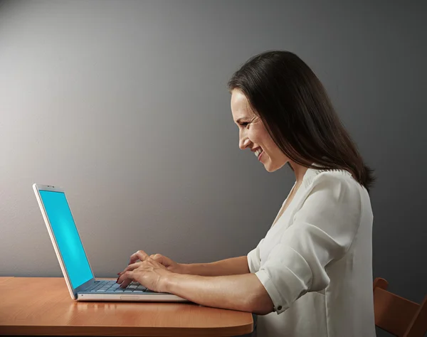 Glada kvinna som arbetar med laptop — Stockfoto
