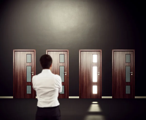 Man looking at four doors — Stock Photo, Image