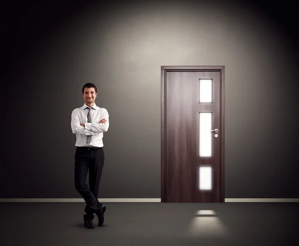 Man standing against wall with door — Stock Photo, Image