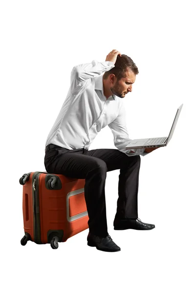 Muž sedí na kufru a při pohledu na notebook — Stock fotografie