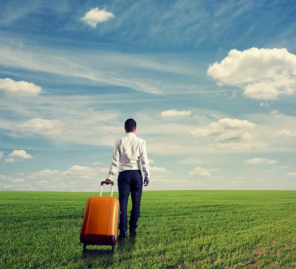 Uomo con borsa che cammina attraverso il campo — Foto Stock