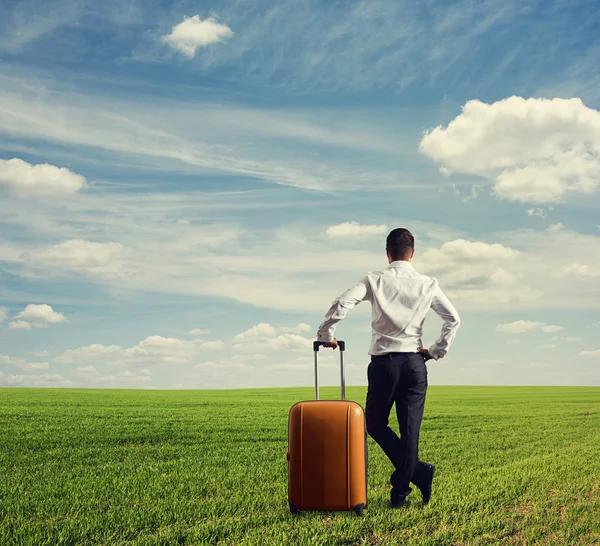 Man with bag standing on the green field — Stock Photo, Image