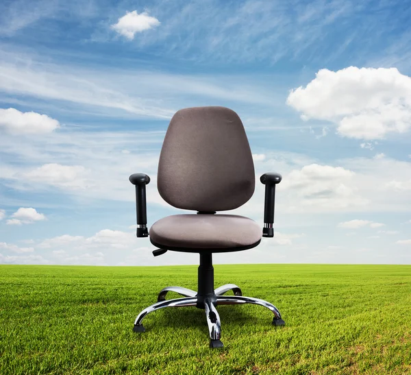 Office chair on green field — Stock Photo, Image