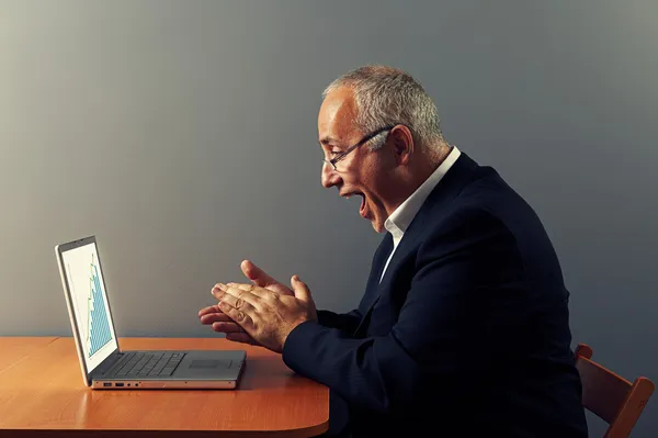 Man looking at graph and rejoicing — Stock Photo, Image