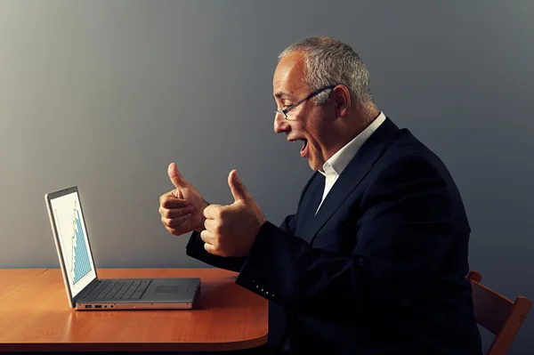 Mann schaut auf Grafik und zeigt Daumen nach oben — Stockfoto