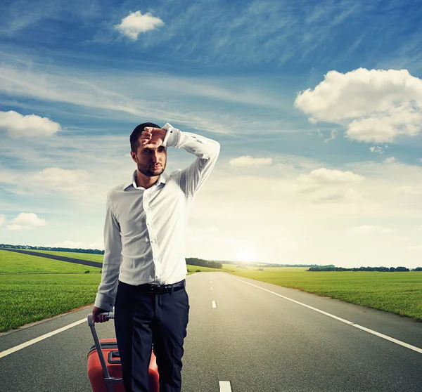 Tired young businessman with suitcase — Stock Photo, Image