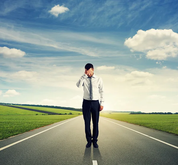 Man standing on the road and looking down — Stock Photo, Image