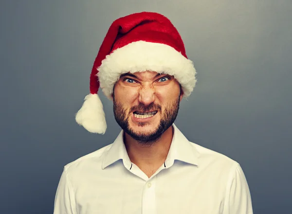 Angry man in Kerstman hoed over grijs — Stockfoto