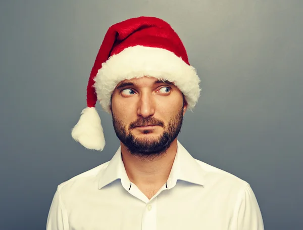 Mannen i santa hatt tittar på något — Stockfoto