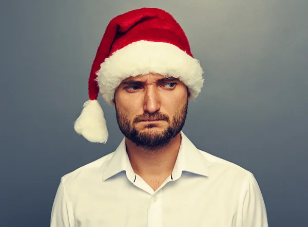 Santa šťastná dívka ukazuje palec可悲的男人在圣诞老人帽子在黑暗中 — 图库照片