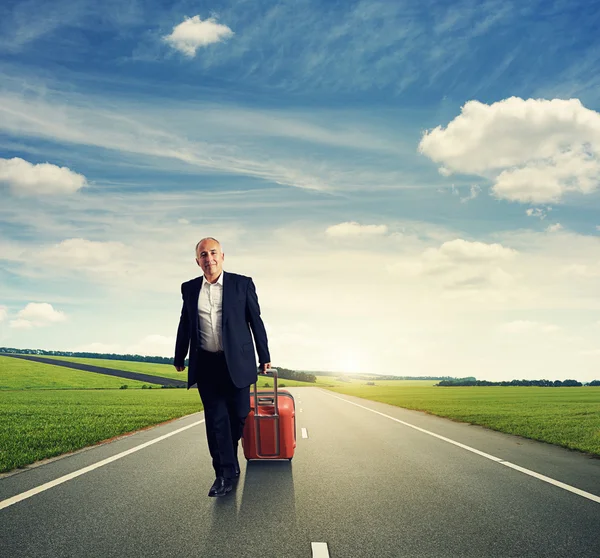 Hombre caminando en el camino y sonriendo — Foto de Stock