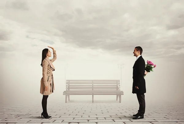 Frau begrüßt Mann mit Blumen — Stockfoto