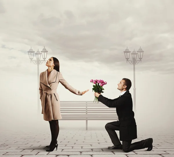 Mulher rejeitando o homem com flores — Fotografia de Stock