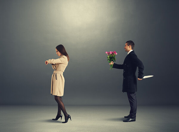 man with flowers behind woman