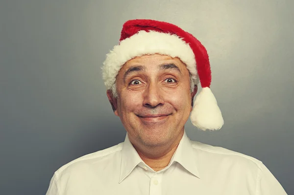 Smiley senior man in red santa hat — Stock Photo, Image