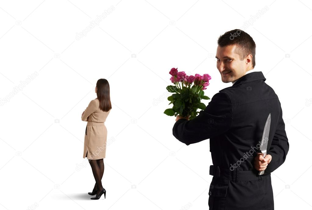 man with knife standing behind woman