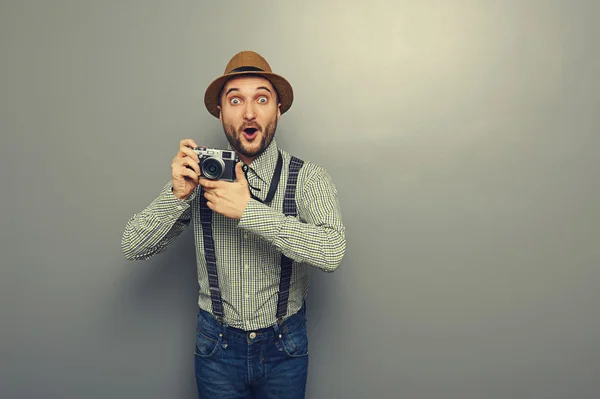 Verblüffter junger Mann mit Kamera — Stockfoto