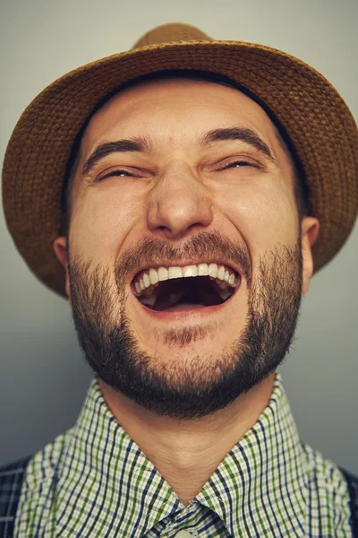 Hombre hipster riendo sobre gris — Foto de Stock