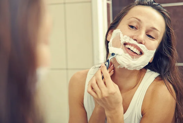 Mujer afeitándose la cara — Foto de Stock