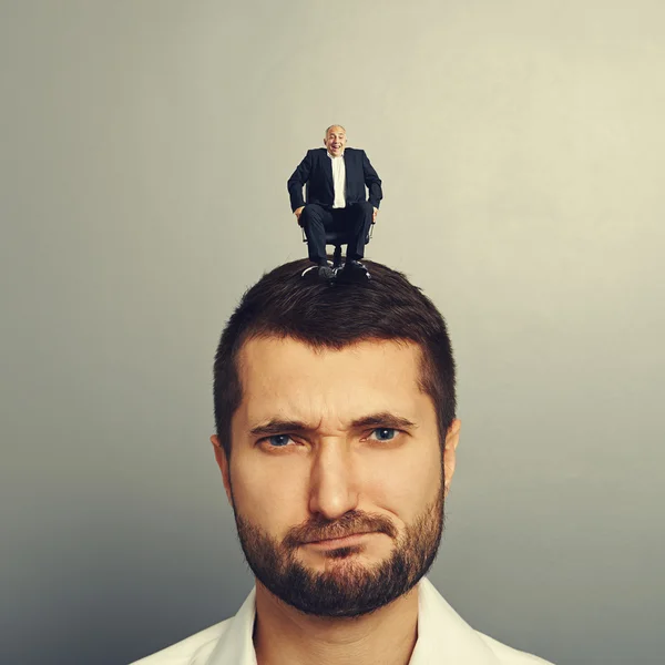 Uomo scontento con piccolo capo sulla testa — Foto Stock