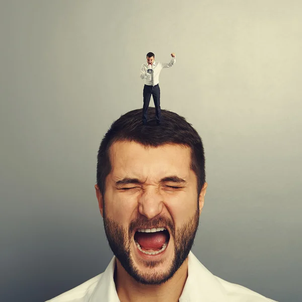 Small angry boss standing on the head — Stock Photo, Image