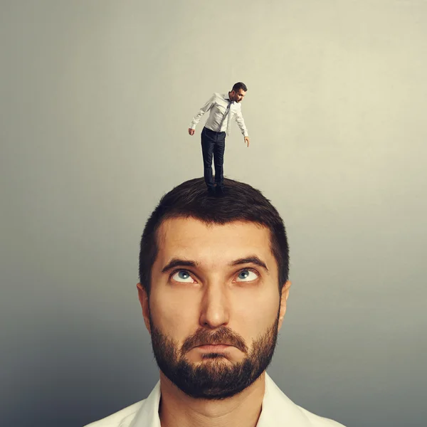 Stupido uomo con piccolo uomo sulla testa — Foto Stock