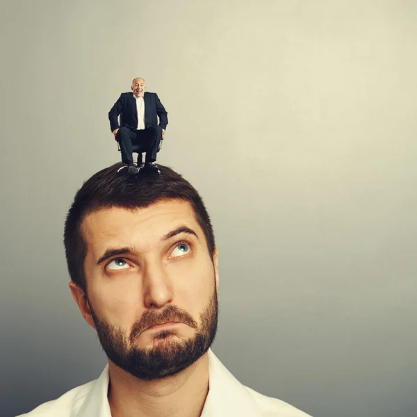 Surprised man looking up at small man — Stock Photo, Image