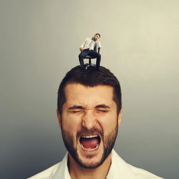 Uomo con piccolo uomo annoiato sulla testa — Foto Stock