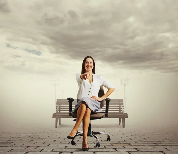 Vrouw zitten op de stoel en wijzen — Stockfoto