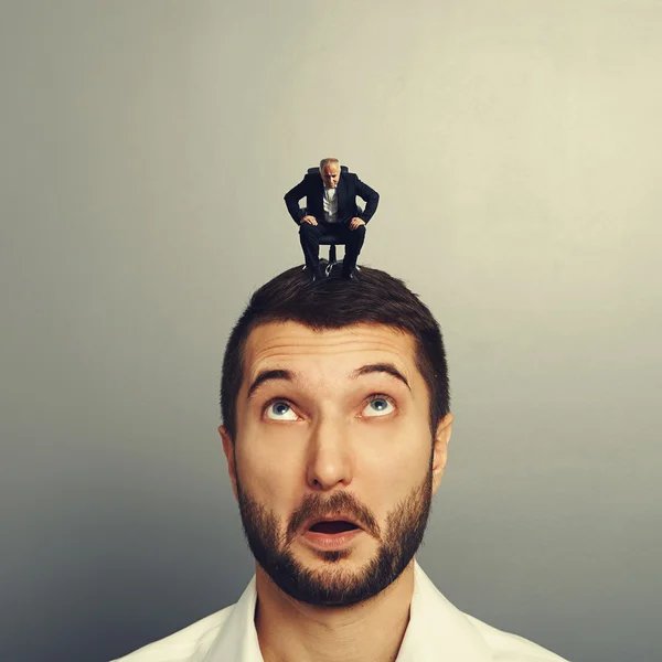 Uomo d'affari guardando il piccolo uomo anziano — Foto Stock