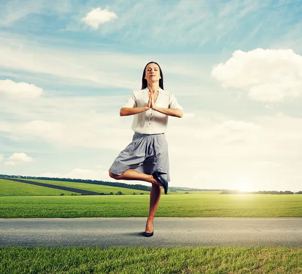 Vrouw in asana op de weg — Stockfoto