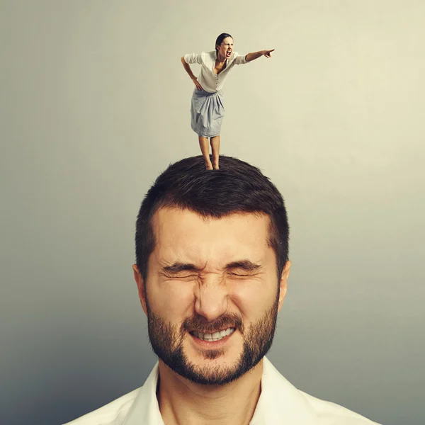 不満の男の頭の上に立っている女性 — ストック写真