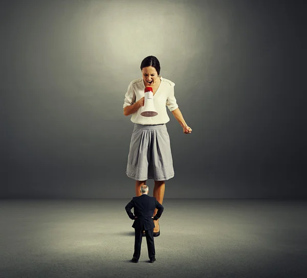 Woman screaming with megaphone at man — Stock Photo, Image