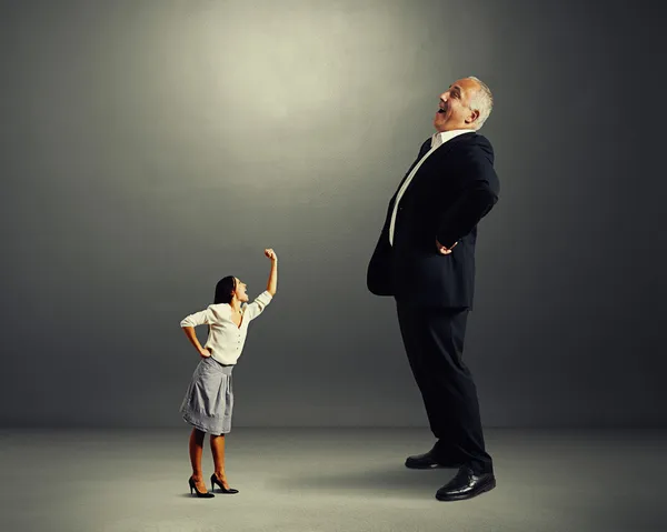 Woman screaming at big laughing businessman — Stock Photo, Image