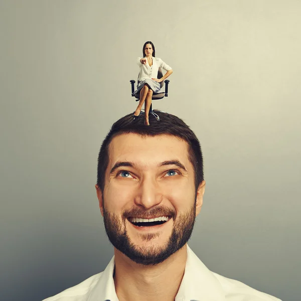 Woman sitting on the head of smiley man — Stock Photo, Image