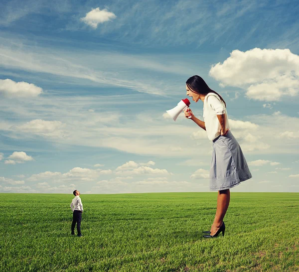 Angry woman and small man on the field — Stock Photo, Image