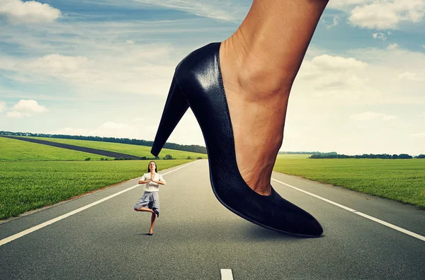 Business woman standing under big heel — стоковое фото