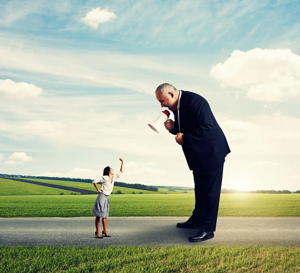 Woman showing fist to big screaming man — Stock Photo, Image