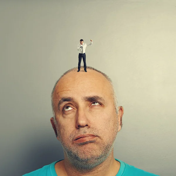 Hombre mayor cansado con pequeño hombre enojado —  Fotos de Stock