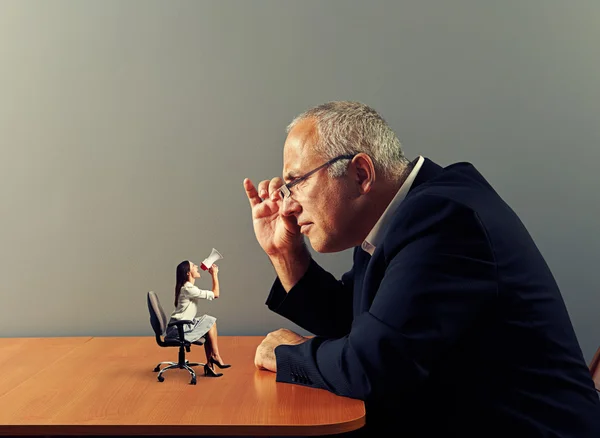 Boss looking at small woman with megaphone — Stock Photo, Image