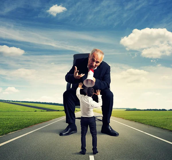 Hombre gritando a asustado pequeño hombre — Foto de Stock