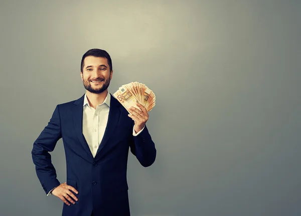 Hombre de negocios sosteniendo papel moneda —  Fotos de Stock