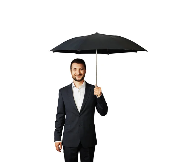 Smiley businessman under umbrella — Stock Photo, Image