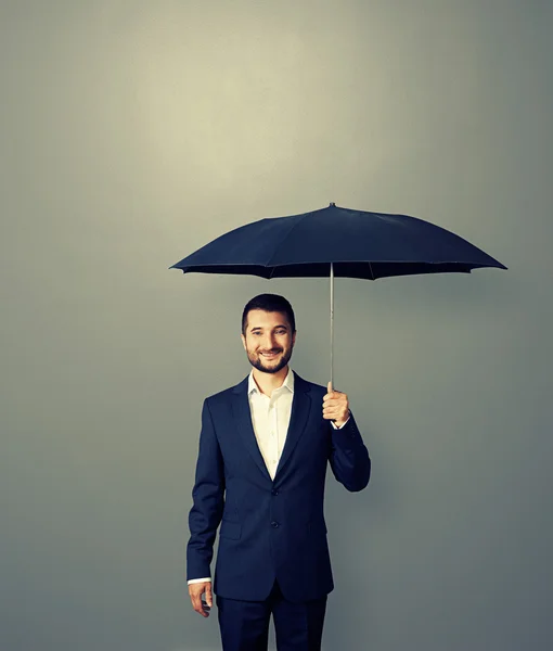Handsome successful businessman with umbrella — Stock Photo, Image