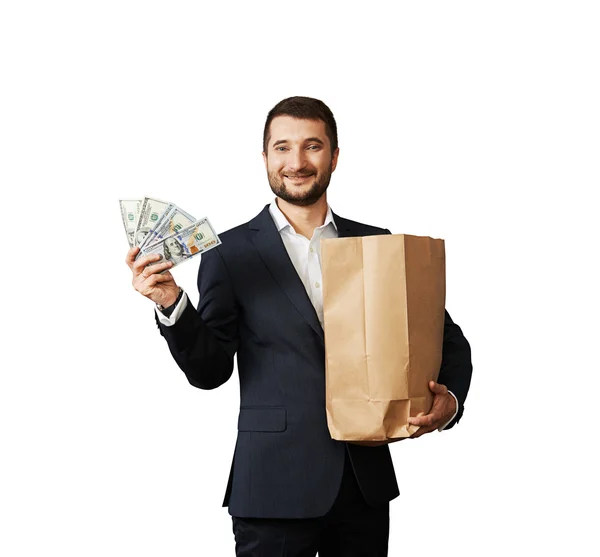 Man holding paper bag and money — Stock Photo, Image