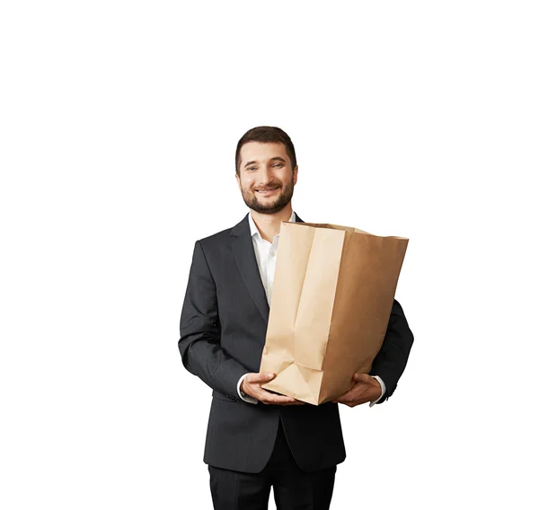 Homem de negócios sorridente segurando saco de papel — Fotografia de Stock