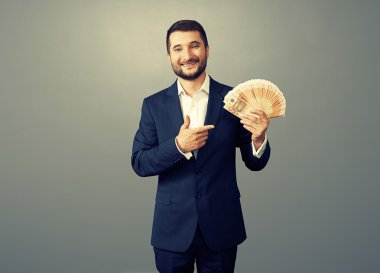 Karanlık üzerinde kağıt para ile işadamı