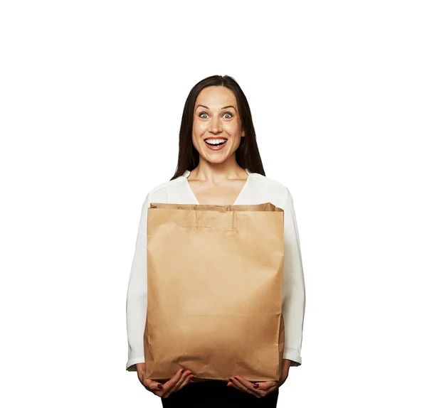 Vzrušená žena drží papírový sáček — Stock fotografie