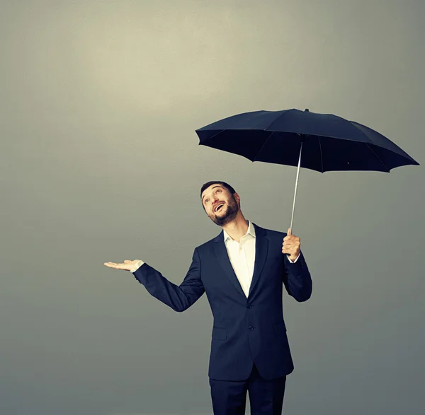 Homme d'affaires souriant avec parapluie — Photo